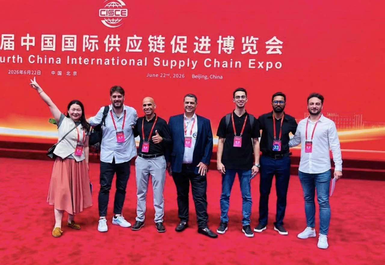 Foto grupal frente al panel de la Exposición Internacional de Cadenas de Suministro, Beijing.